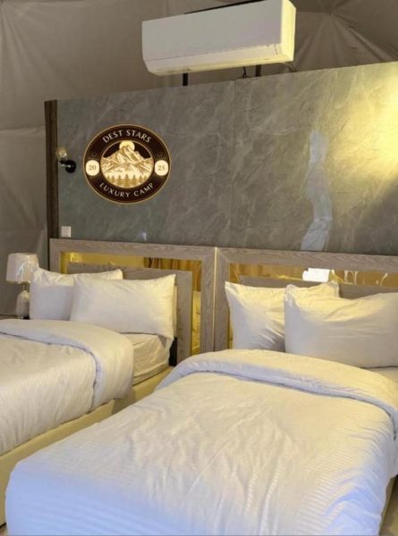 Habitación doble twin con camas blancas y decoración dorada en Dest Stars Luxury Camp