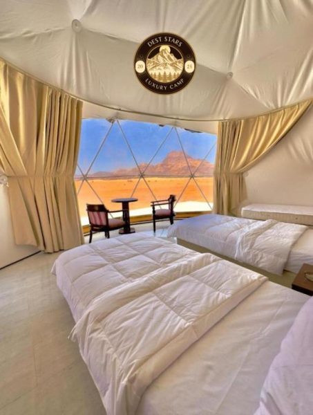 Interior de domo glamping con camas dobles y vistas panorámicas al desierto en Dest Stars Luxury Camp