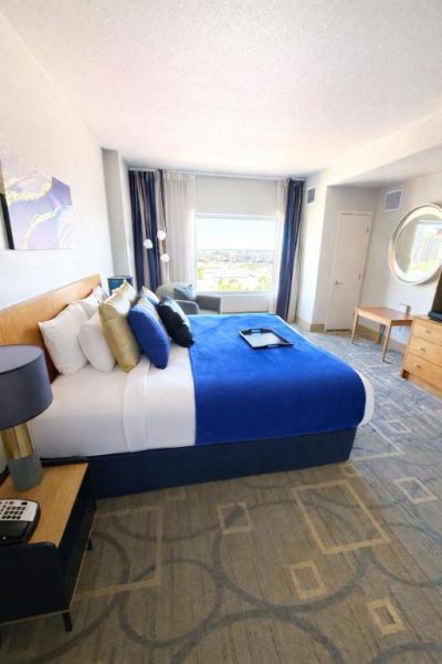 Habitación king size con decoración azul y vistas a la ciudad en Idyllic Suite Las Vegas