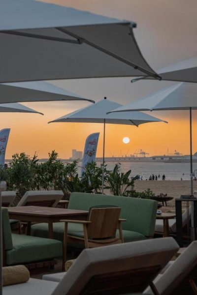 Terraza con tumbonas y sombrillas frente a la playa de The View Agadir con vistas al atardecer
