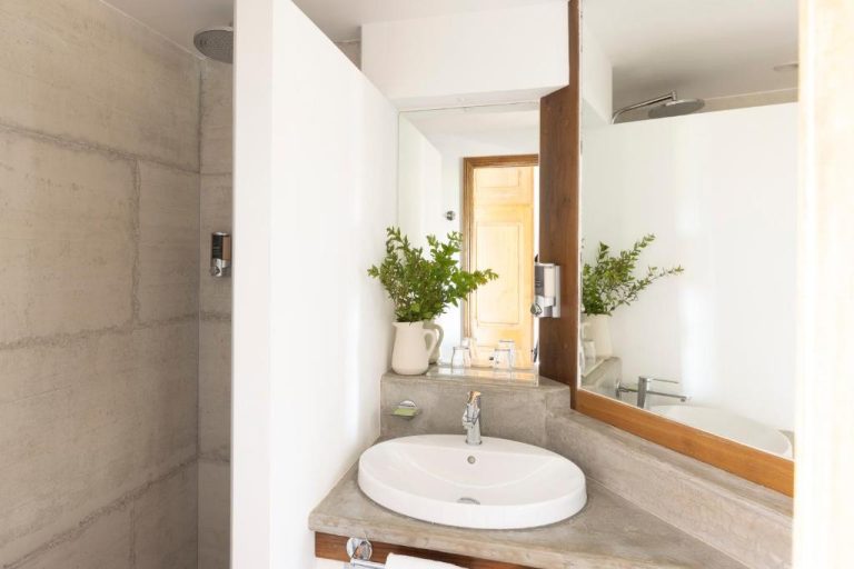 Baño moderno con lavabo empotrado y ducha de piedra natural en el hotel U Capu Biancu