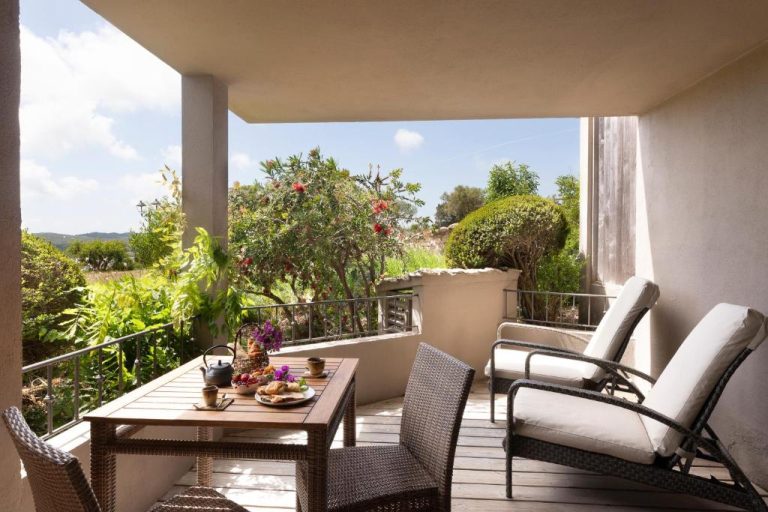 Terraza con desayuno y vistas al jardín mediterráneo en el Hotel U Capu Biancu
