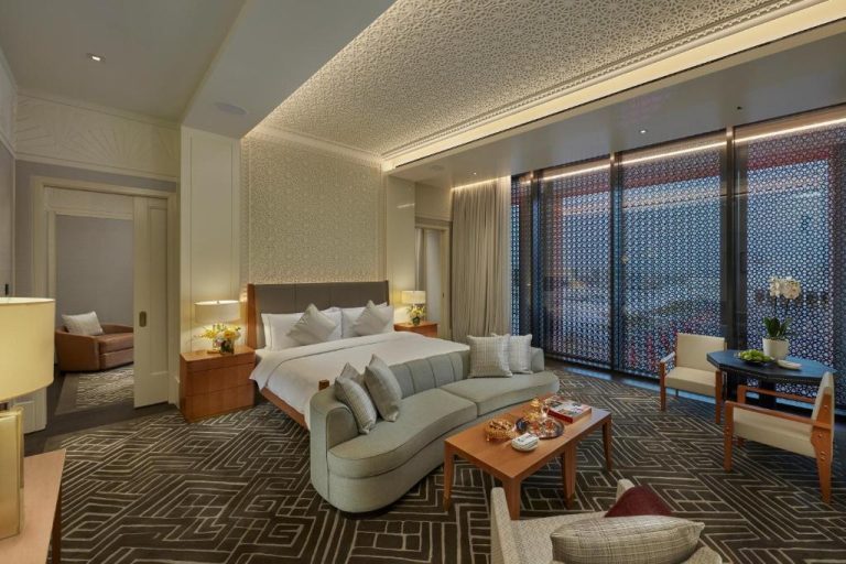 Suite de lujo con cama king y sofá en Mandarin Oriental Doha con vistas panorámicas a la ciudad