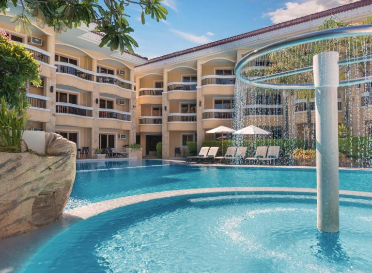 Piscina exterior con fuente circular y vistas al edificio del Henann Regency Resort and Spa en Boracay