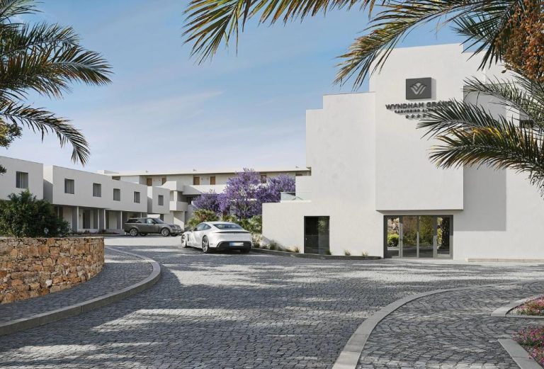 Entrada principal del Wyndham Grand Carvoeiro Algarve con aparcamiento y jardines con palmeras
