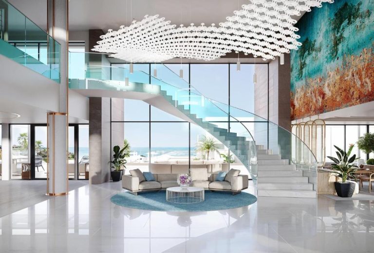 Lujoso lobby del Wyndham Grand Carvoeiro Algarve con escalera de cristal y vistas al mar