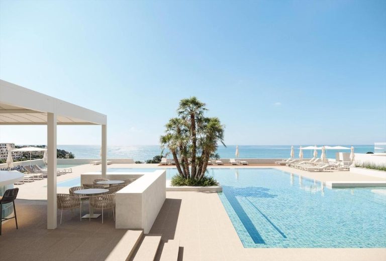 Piscina infinita con vistas al mar del Wyndham Grand Carvoeiro Algarve y zona de tumbonas