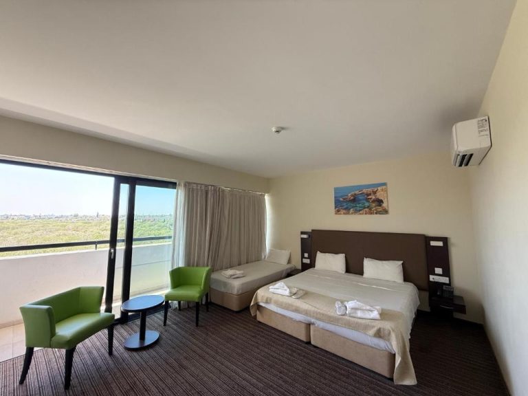 Habitación triple con cama doble, sofá cama y balcón con vistas al jardín en Christofinia Hotel