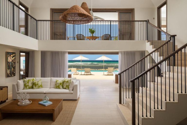 Lujoso salón con vista a la piscina infinita y playa del resort Half Moon en Jamaica