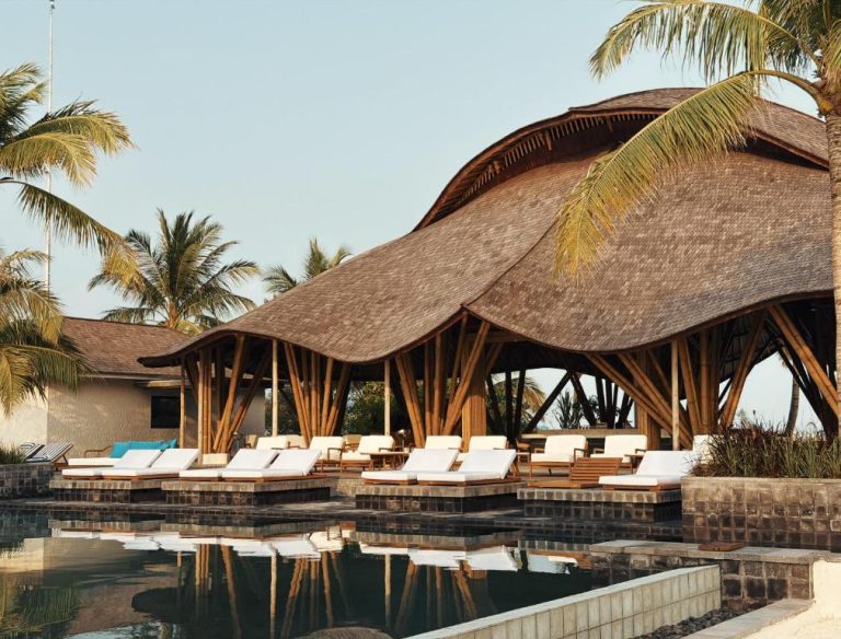 Piscina exterior con tumbonas y pabellón de bambú tropical en RAH GILI Maldives
