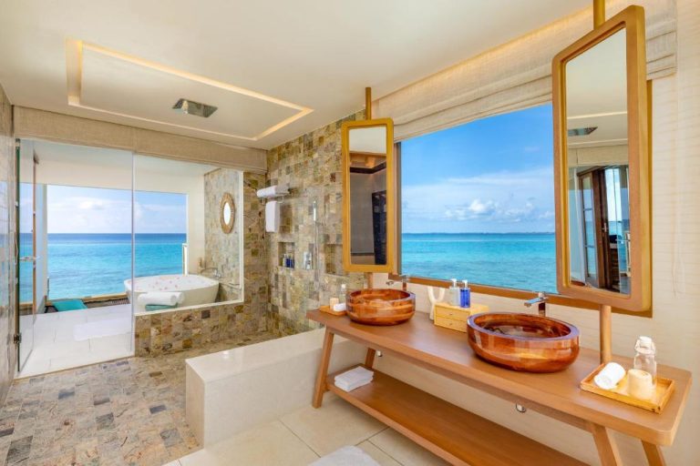 Baño de lujo con lavabos de madera y vistas al océano turquesa en RAH GILI Maldives
