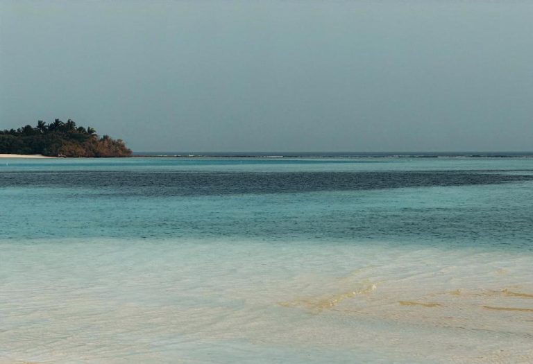 Playa de arena blanca con laguna turquesa y isla tropical en el resort RAH GILI Maldives