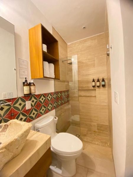 Baño moderno con ducha de cristal y azulejos decorativos en Latino Hotel Boutique