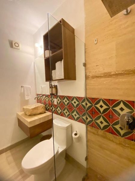 Baño moderno con ducha de cristal y azulejos decorativos en Latino Hotel Boutique