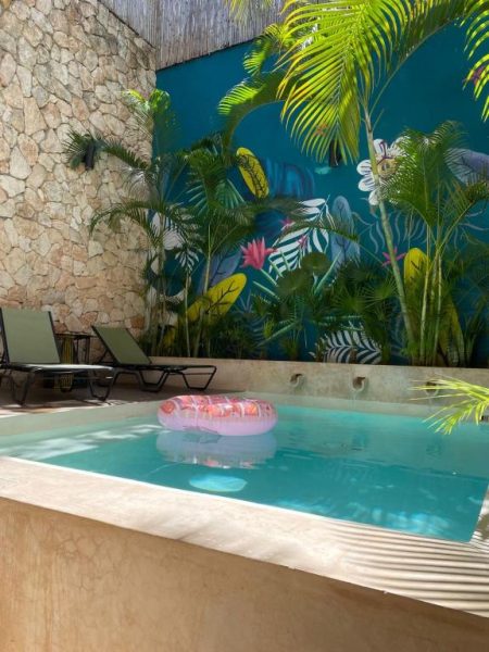 Piscina privada con flotador y mural tropical del Latino Hotel Boutique en México