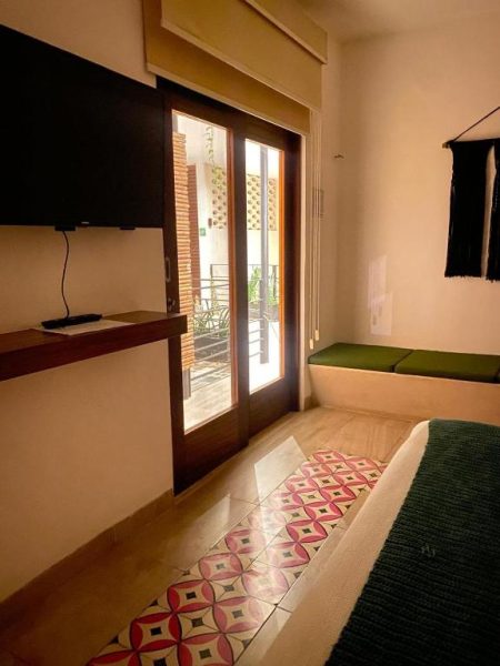 Habitación con suelo de azulejos artesanales y terraza exterior en Latino Hotel Boutique