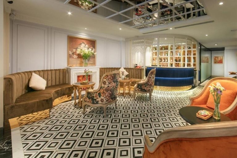 Elegante lobby bar con sofás de terciopelo y suelo geométrico en Solar Premium Hotel & Spa