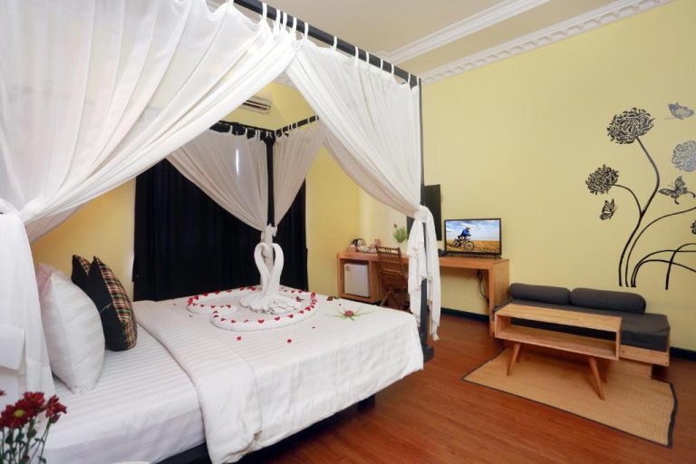 Habitación romántica con cama dosel y decoración de cisnes en Central Boutique Hotel