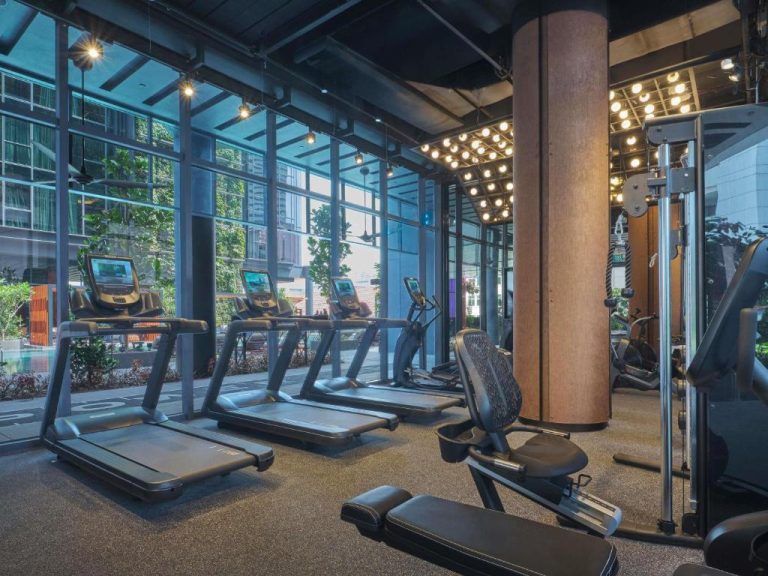 Gimnasio moderno con cintas de correr y vistas panorámicas al exterior en el Pullman Singapore Hill Street