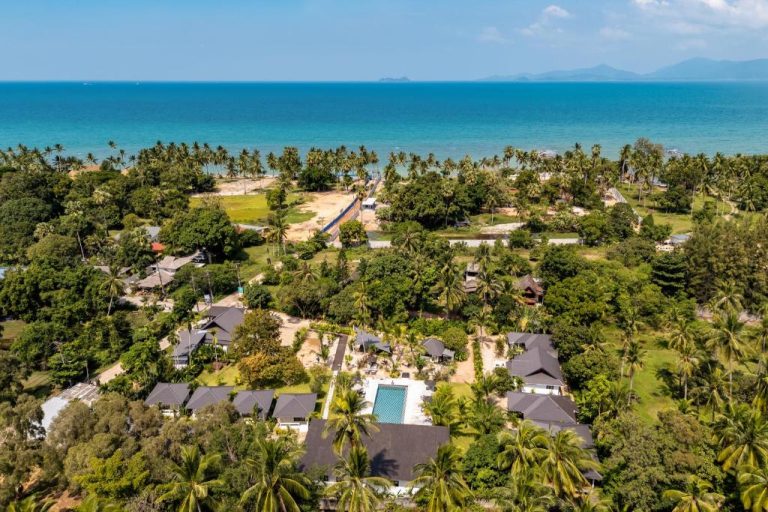 Vista aérea del Moorea Boutique Resort Samui con piscina exterior rodeada de palmeras y villas frente al mar