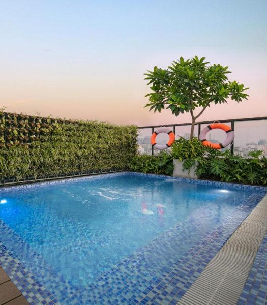 Piscina exterior en la azotea del Solar Premium Hotel & Spa con jardín vertical y vistas a la ciudad