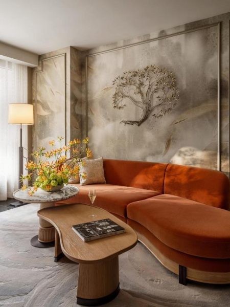 Elegante salón con sofá naranja terciopelo y decoración artística en Mandarin Oriental The Landmark Hong Kong