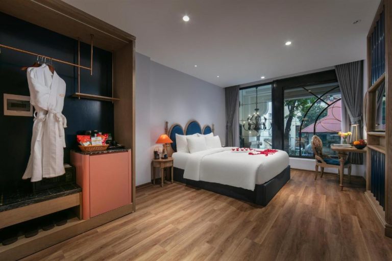 Habitación doble decorada con pétalos de rosas en Solar Premium Hotel & Spa con suelo de madera