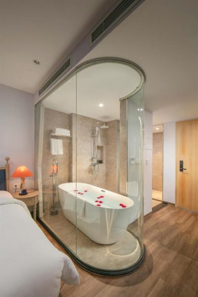 Bañera exenta con pétalos de rosa en suite de cristal del Solar Premium Hotel & Spa