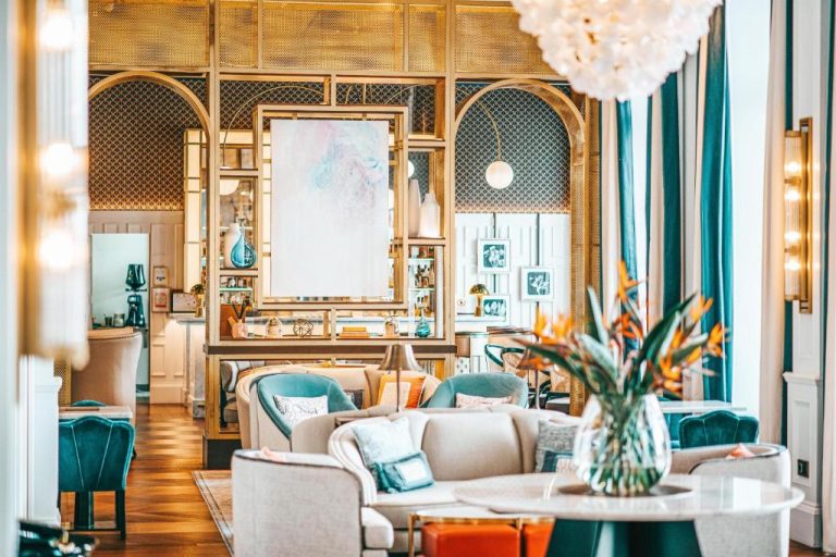 Elegante salón lounge del Hilton Imperial Dubrovnik con sofás, decoración dorada y cortinas turquesa