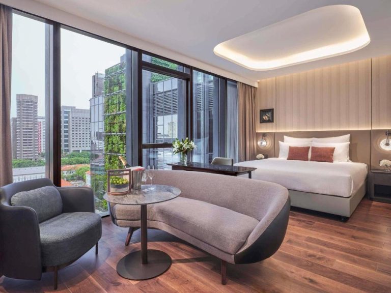 Habitación deluxe con sofá curved, cama king y vistas al skyline en Pullman Singapore Hill Street