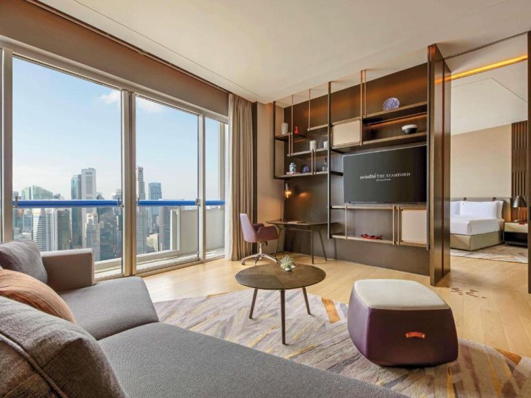 Suite con sala de estar y vistas panorámicas al skyline de Singapur en Swissotel The Stamford