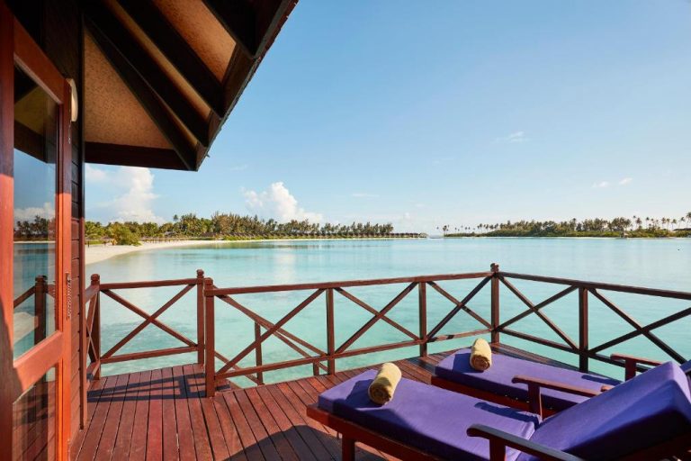 Terraza sobre el agua con tumbonas y vistas a la laguna turquesa en Sun Siyam Olhuveli Maldivas