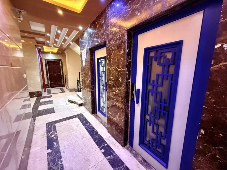 Ascensores decorados en azul y dorado en el lujoso lobby de mármol del Hotel Winter House