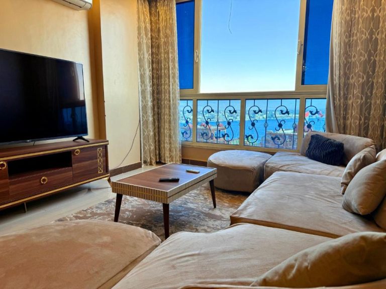 Salón luminoso con sofás y televisión con vistas al río Nilo en el apartamento Winter House