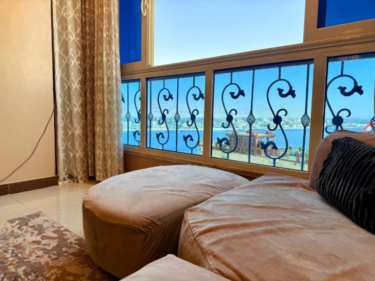 Salón con sofá y ventana con herrería decorativa y vistas al mar en Winter House