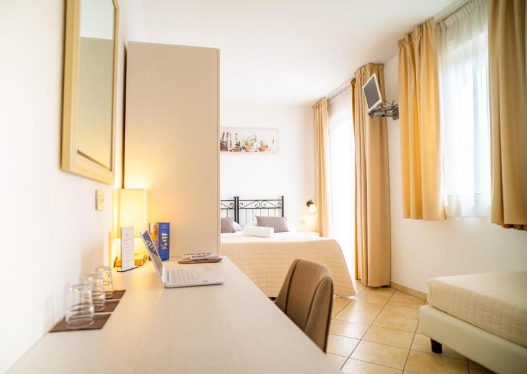 Habitación doble con escritorio, sofá y cama matrimonial en el Hotel Sylesia