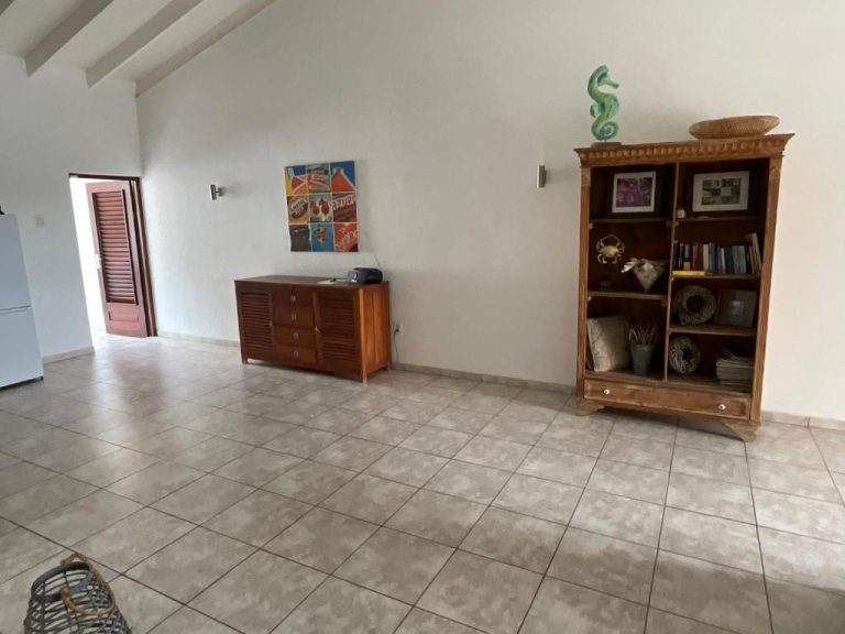 Amplio salón con estantería de madera y suelo de baldosas en Bantopa Apartments