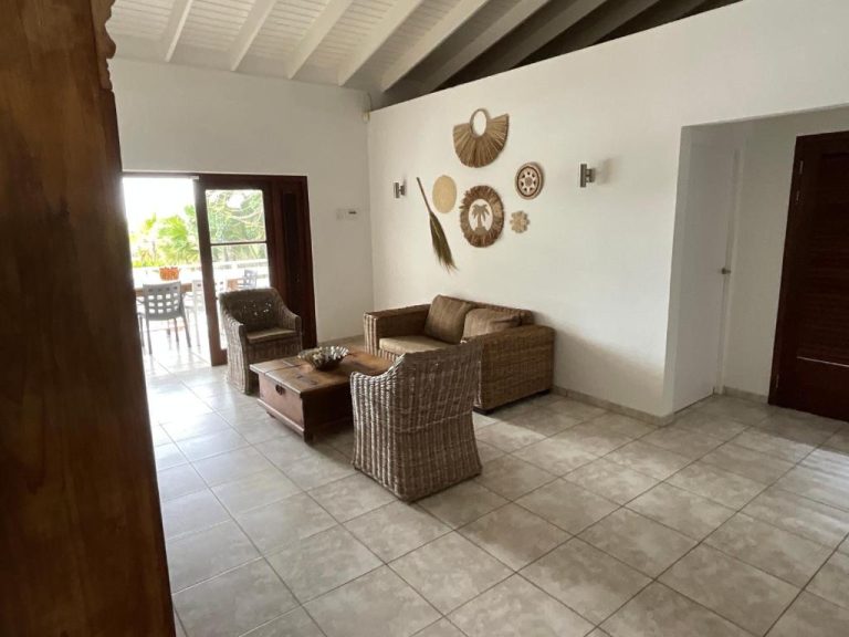 Sala de estar con muebles de ratán y decoración tropical en Bantopa Apartments