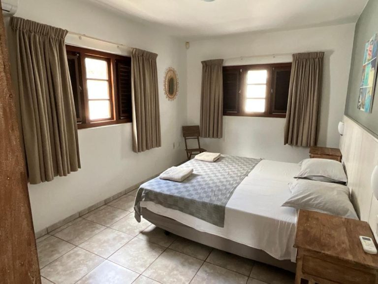 Habitación doble con cama matrimonial y ventanas con cortinas en Bantopa Apartments