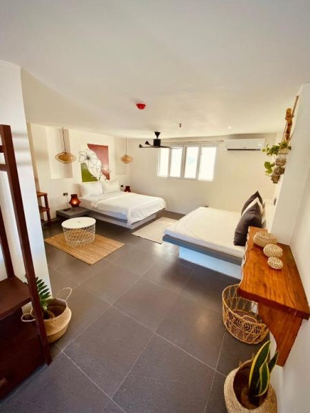 Habitación doble con dos camas y decoración tropical natural en Happiness Hostel Boracay
