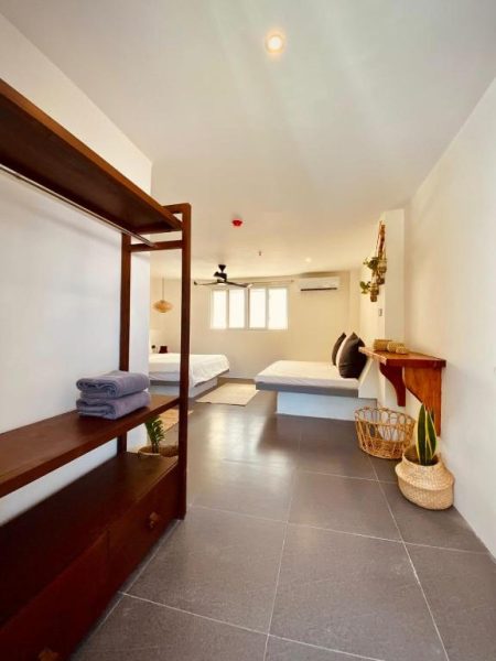 Habitación doble moderna con dos camas y estantería de madera en Happiness Hostel Boracay