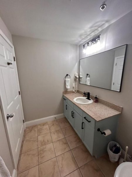 Baño moderno con lavabo y encimera de granito en Stunning Gulf View Condo con acceso directo a la playa
