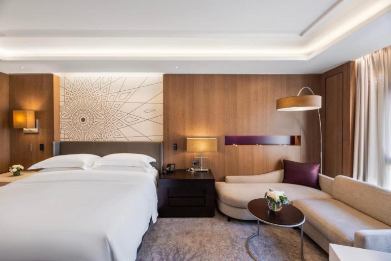 Habitación deluxe con cama king size y zona de sofá en InterContinental Doha Beach & Spa