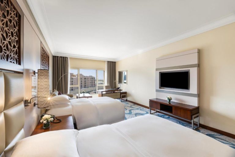 Habitación doble con dos camas y televisión del InterContinental Doha Beach & Spa con vistas a la ciudad