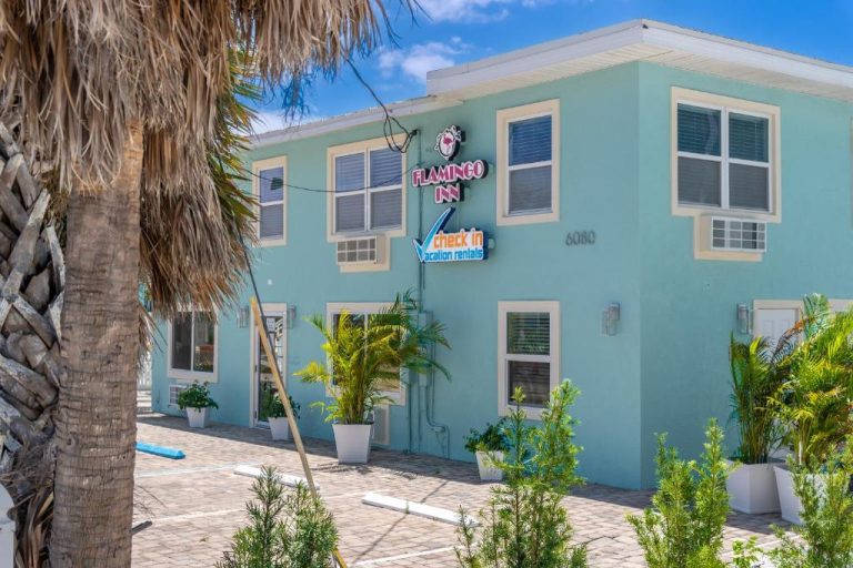 Fachada exterior del Flamingo Inn con palmeras y jardines tropicales en ambiente costero de Florida