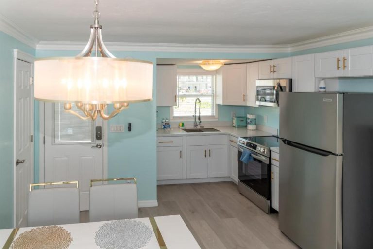 Cocina equipada con electrodomésticos modernos y comedor con lámpara en Flamingo Inn