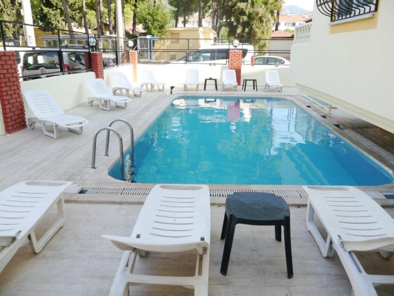 Piscina exterior con tumbonas blancas y terraza solarium del Ressa Apart Hotel