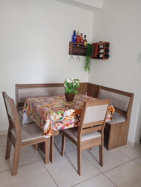 Comedor con mesa y sillas de madera en Hospedagem para Grupos, con barra de bebidas en la pared