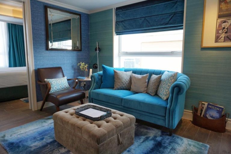 Salón elegante con sofá azul turquesa y decoración moderna en el Hotel Madera Hollywood