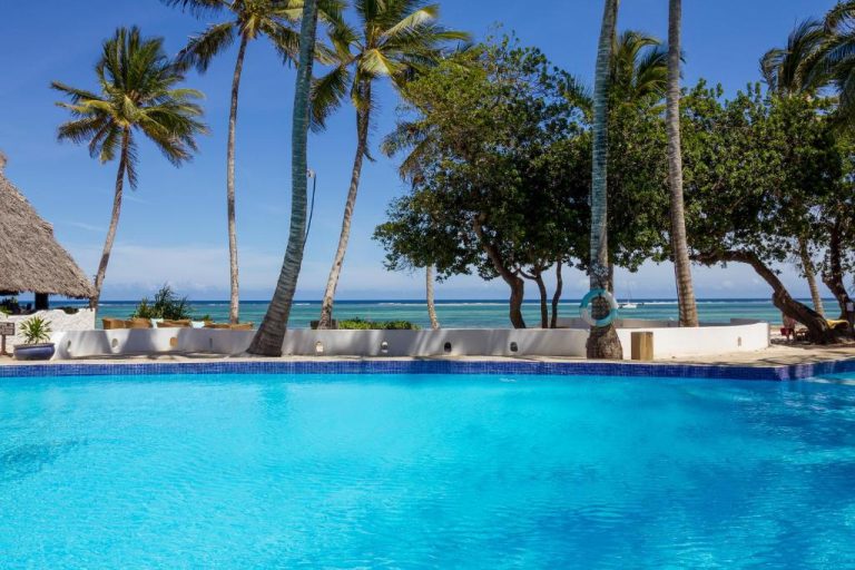 Piscina exterior con vistas al océano y palmeras tropicales en Ocean Village Club Adults Only Zanzíbar